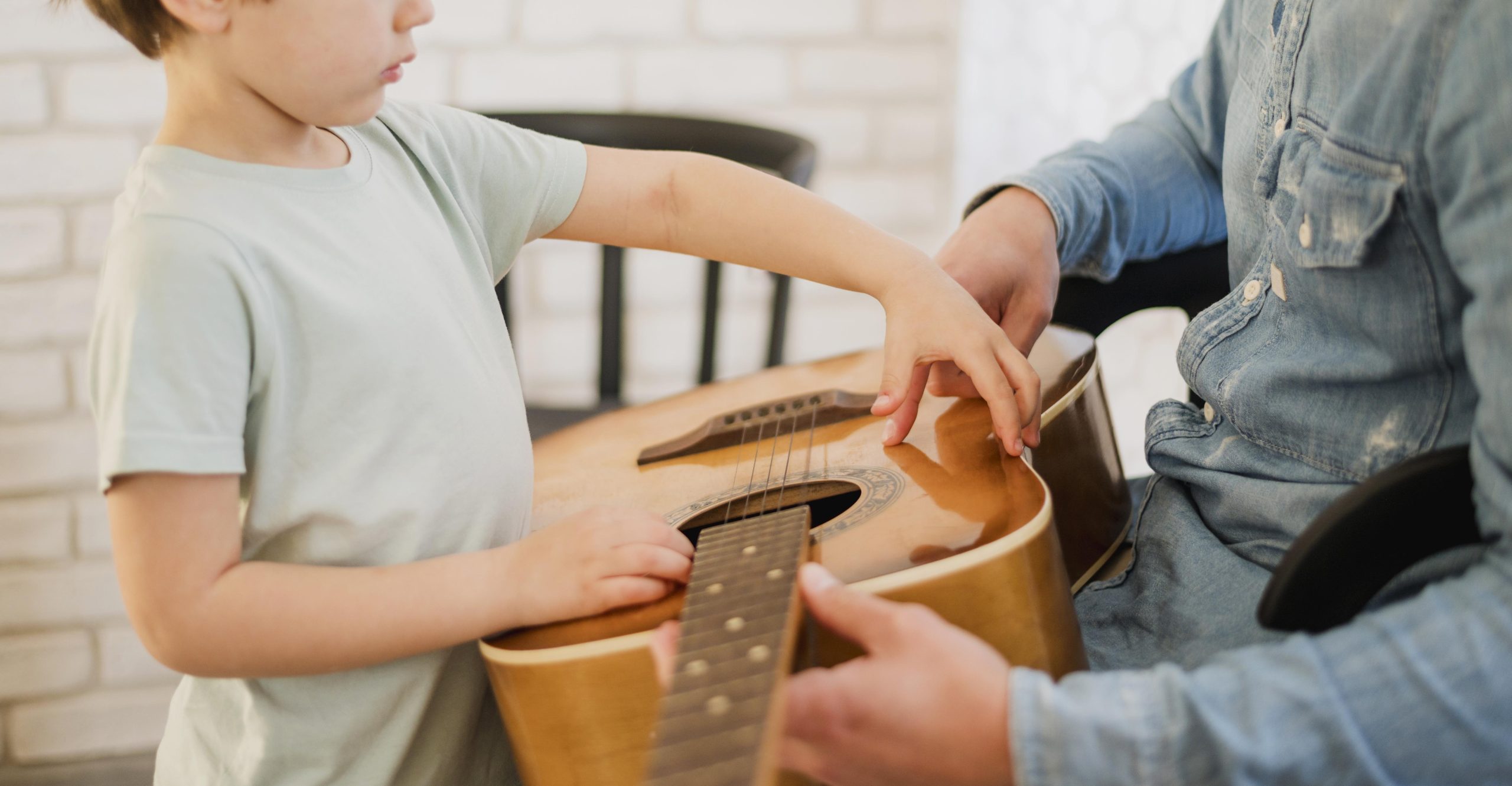 side-view-child-guitar-teacher